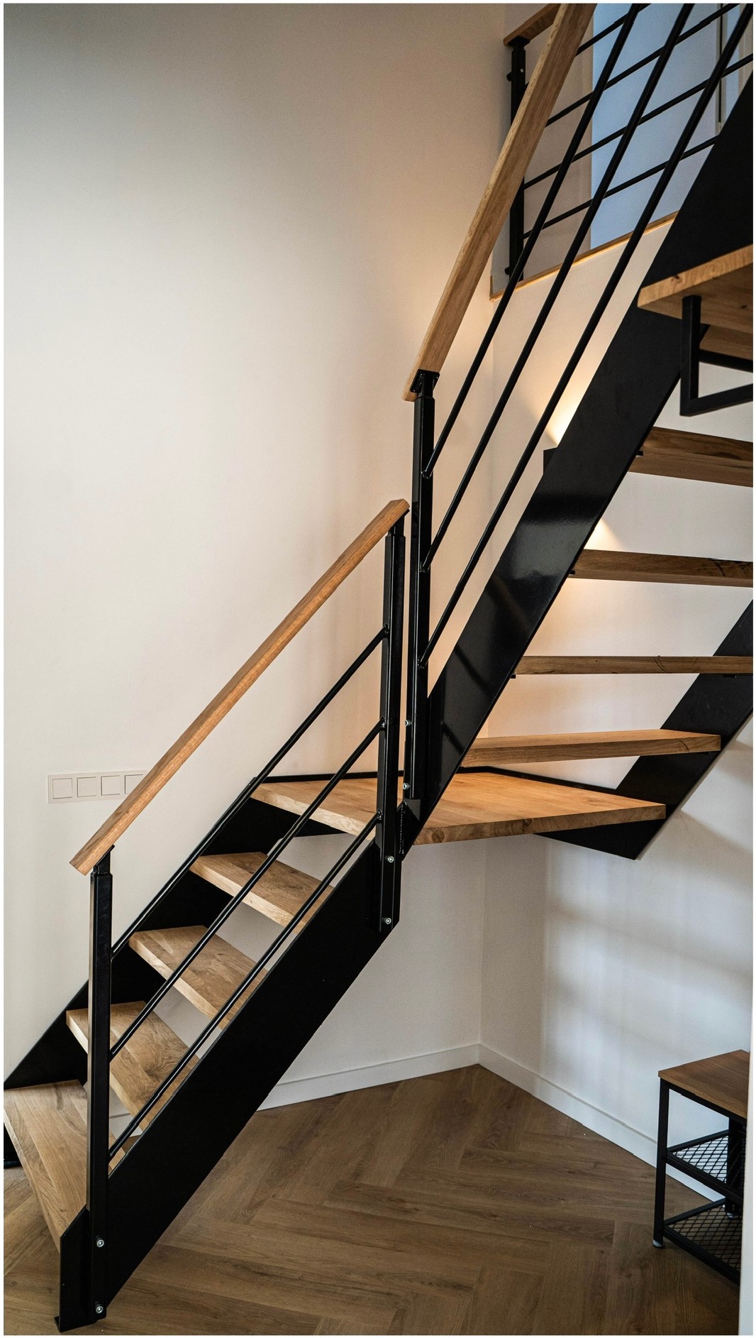 Zwarte stalen trapconstructie met houten treden